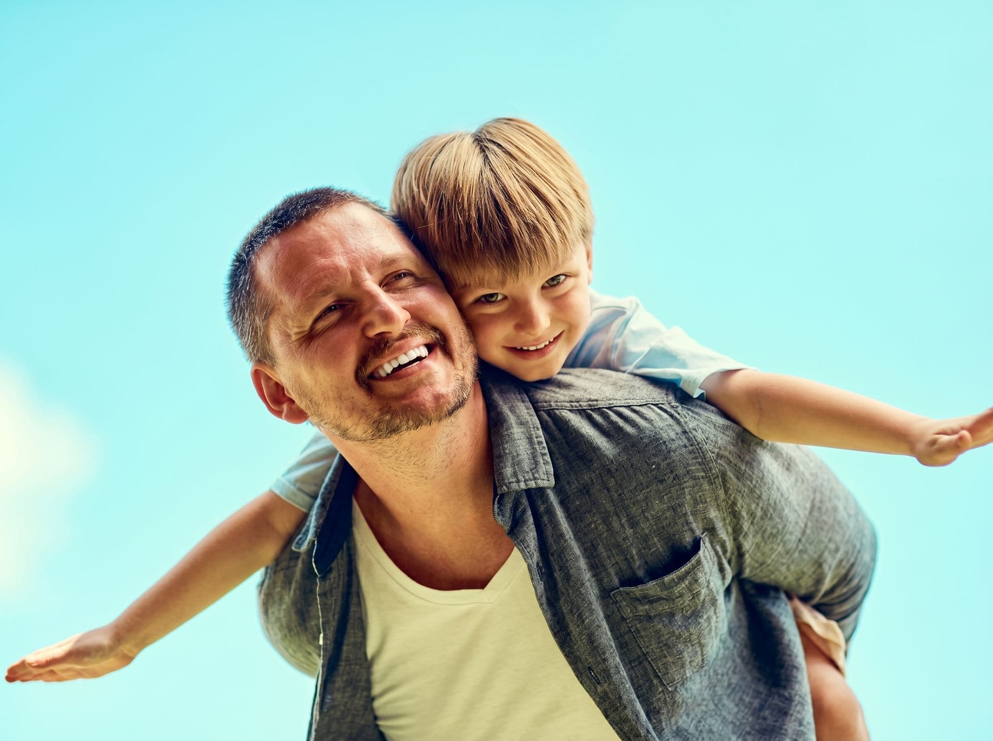 Father and child smiling, representing extractions at East River Dental