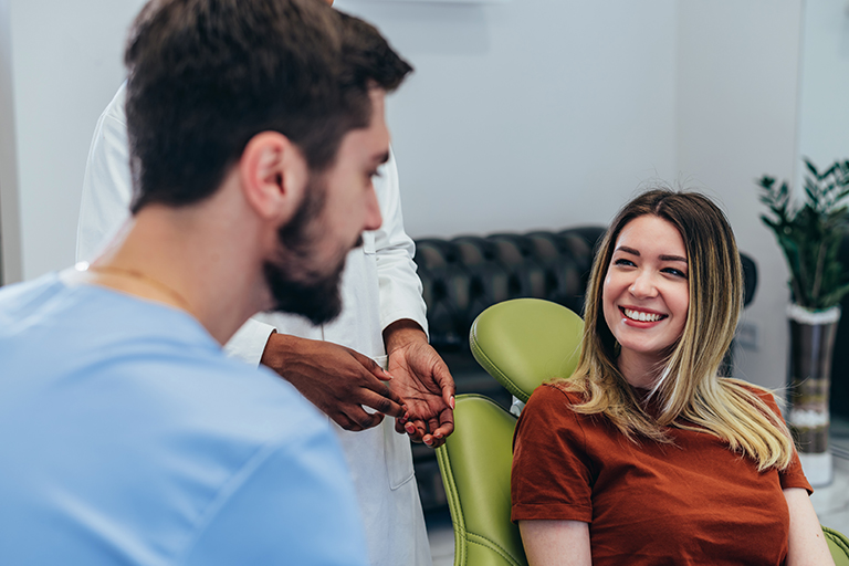 Smiling patient talking with dentist in a modern dental clinic