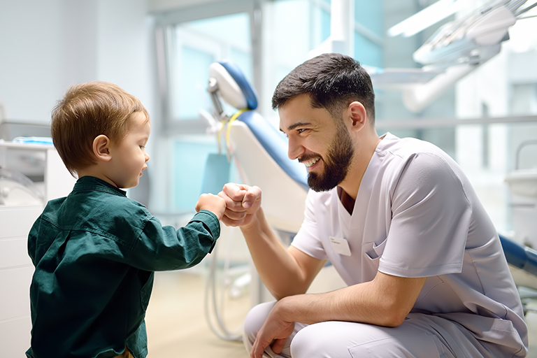 Dentist fist bumping young patient in dental clinic